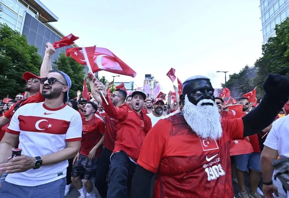 Özellikle Avrupa merkezli bazı spor sayfaları ve futbol platformları, Türk taraftarın renkli görüntülerine yer verirken, Udi Neco’nun tribünlerdeki enerjisi ve sıra dışı görünümü dikkat çekti. Kısa sürede milyonlarca kişiye ulaşan görüntüler, Dünya Kupası’nın unutulmaz taraftar kareleri arasında gösterilmeye başlandı.