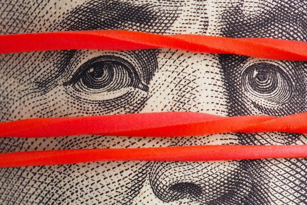 Old 100 Dollar Bill With Franklin Portrait Very Close Up The Banknote Is Pulled By An Elastic Band And On The Face As If A Mask Off Books Money Under The Table Vertical Shot Strong Macro